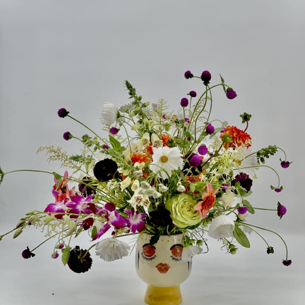 Colorful mixed bouquet in a face-shaped ceramic vase