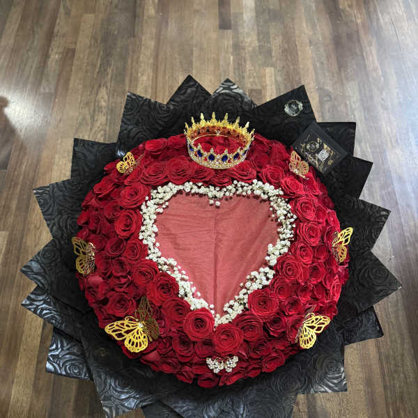 Heart-shaped red rose arrangement with a crown and black wrapping
