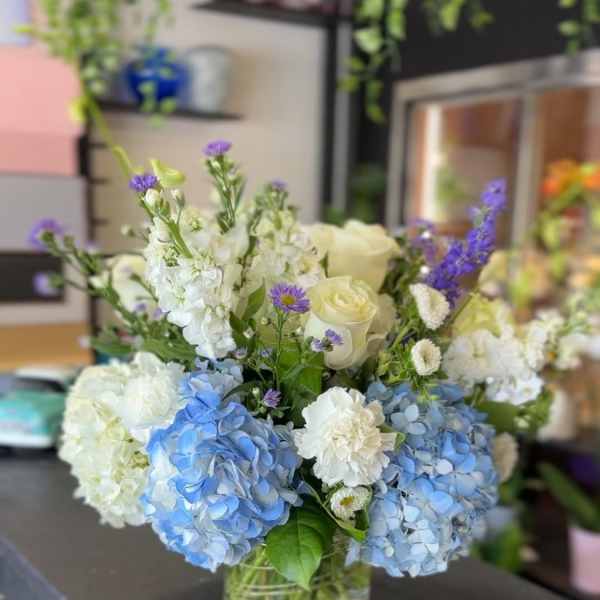 Blue and white flower arrangement in a clear glass vase