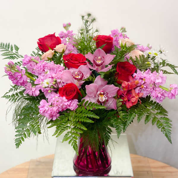 Pink and red mixed bouquet in a magenta glass vase