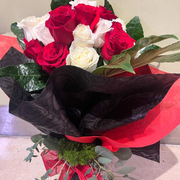 Bouquet of red and white roses wrapped in black and red paper