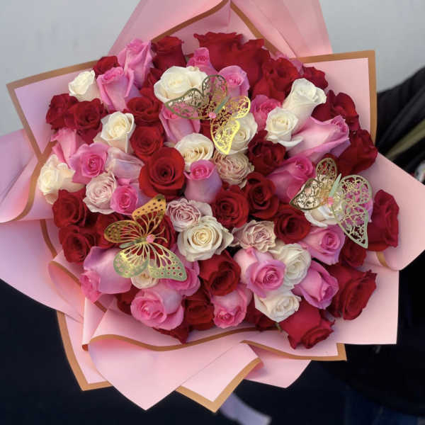 Bouquet of red, pink, and white roses wrapped in pink paper