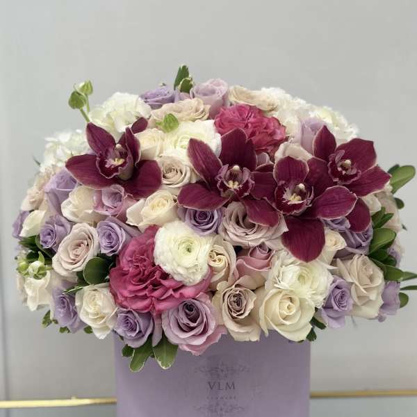 Lavender and white rose bouquet with deep magenta orchids in a round box