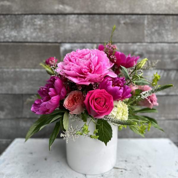 Pink floral arrangement in a white vase