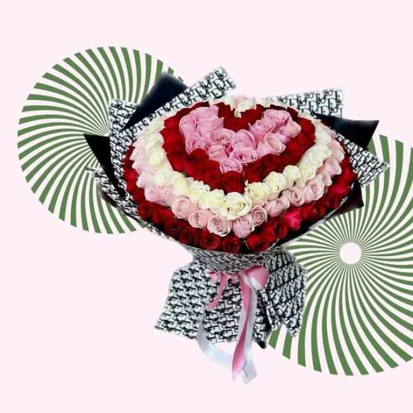 Heart-shaped bouquet of red, pink, and white roses with patterned wrapping