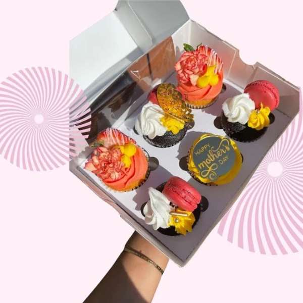 Box of decorated cupcakes with a Mother's Day topper