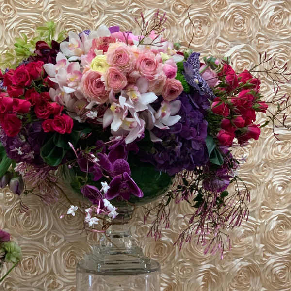 Large bouquet of pink, purple, and white flowers in a clear vase