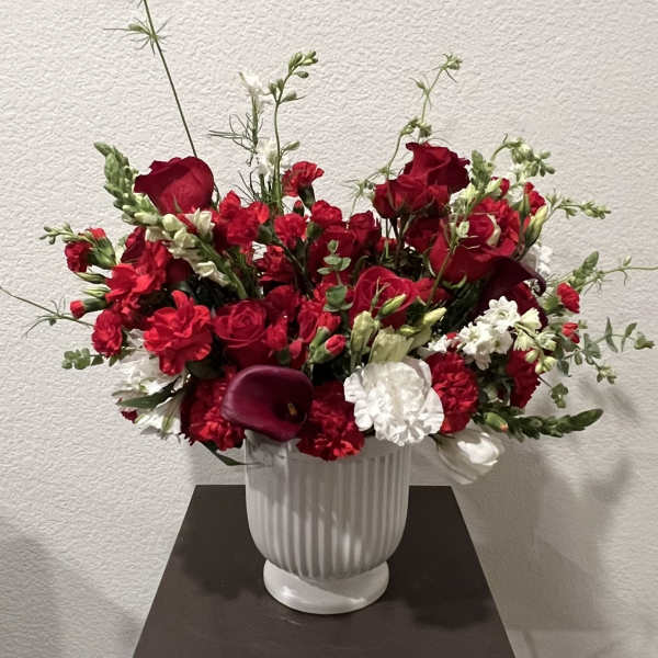 Red and white floral arrangement in a white vase