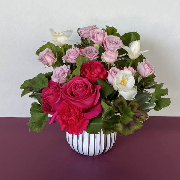 Pink roses and white tulips in a striped vase