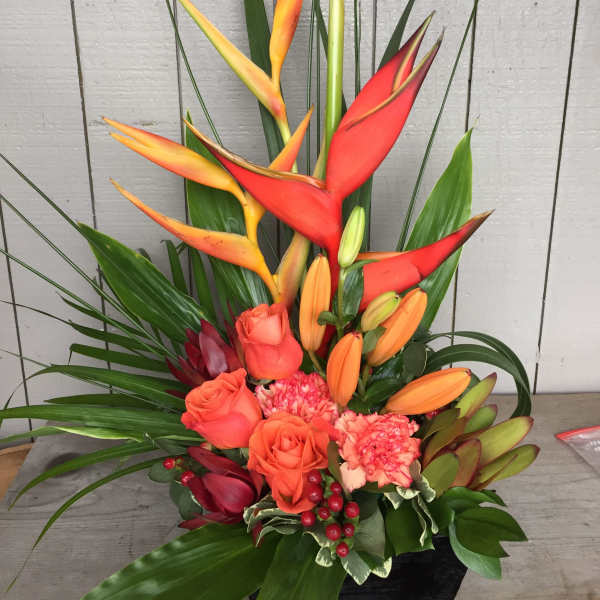 Tropical arrangement with orange roses, lilies, and red heliconia