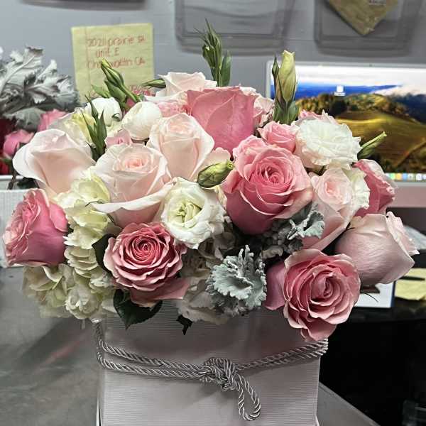 Pink and white rose bouquet in a white box with a rope bow