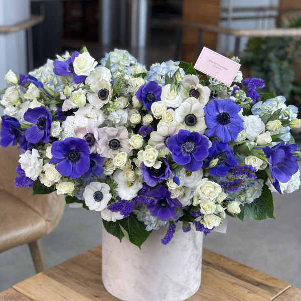 Large bouquet of white and purple flowers in a white vase
