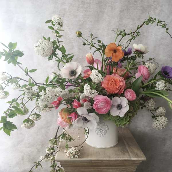 Mixed bouquet in a white vase with pink, orange, purple, and white blooms