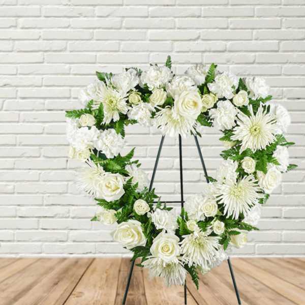 White floral heart wreath on a black easel