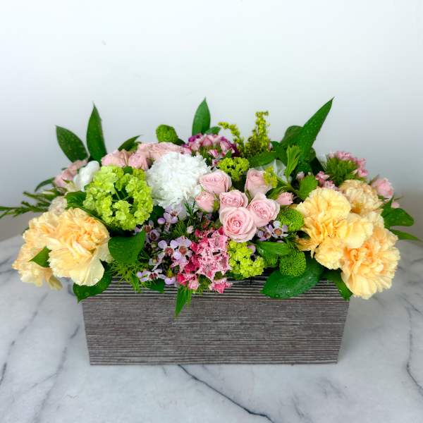 Mixed pastel flower arrangement in a rectangular wooden box