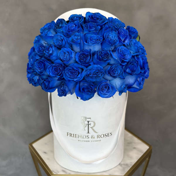 Blue roses arranged in a white hat box
