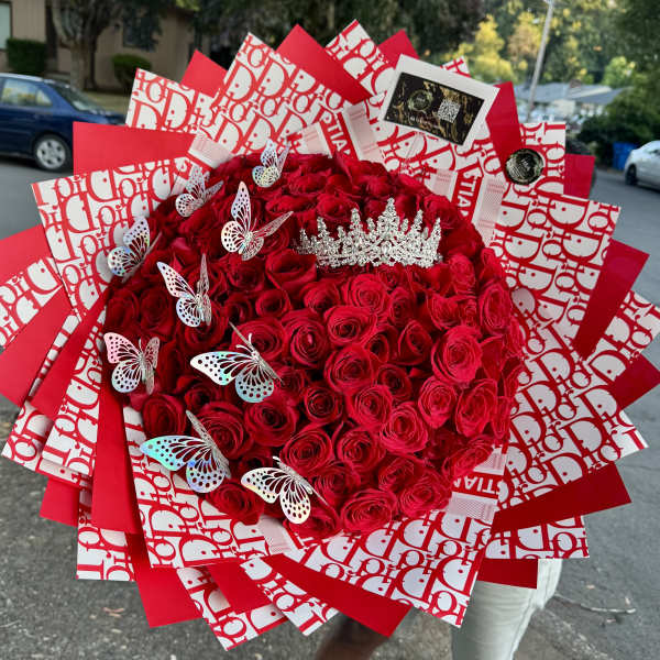 Large bouquet of red roses with butterfly decorations and a jeweled crown