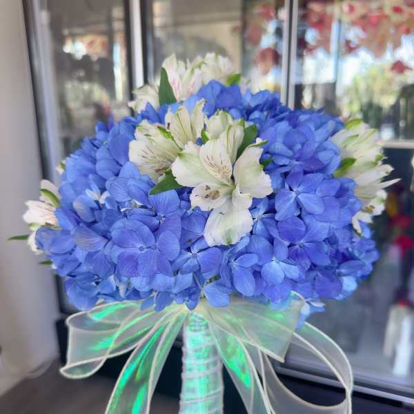 Blue hydrangea bouquet with white alstroemeria and a sheer ribbon handle