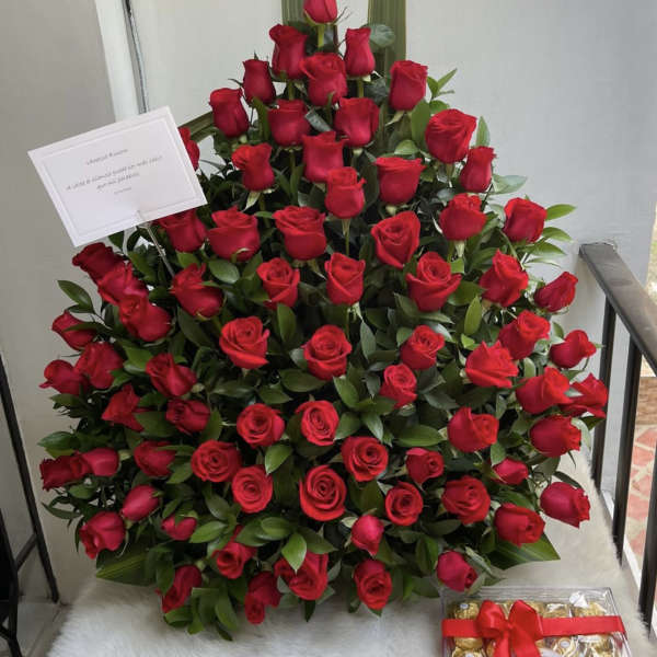 Large arrangement of red roses with a box of chocolates