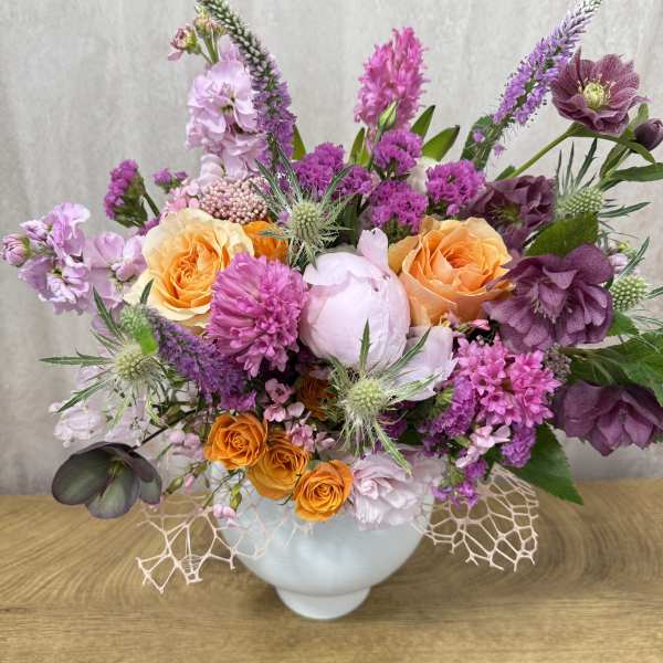 Mixed bouquet in a white vase with orange and purple flowers