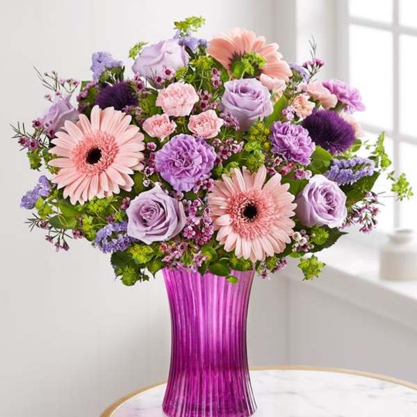 Pink and lavender mixed bouquet in a purple glass vase