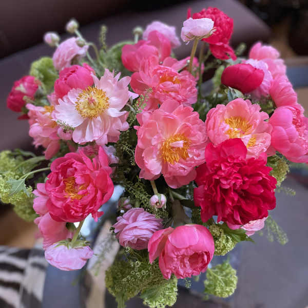Bouquet of pink peonies and pale pink blooms with green filler