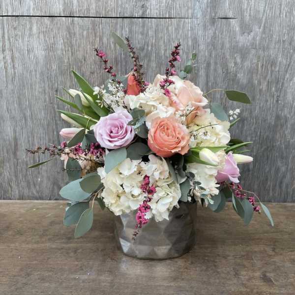 Bouquet of pastel roses and white hydrangeas in a gray vase