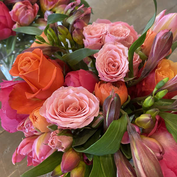 Bouquets of pink, orange, and coral roses with mixed blooms