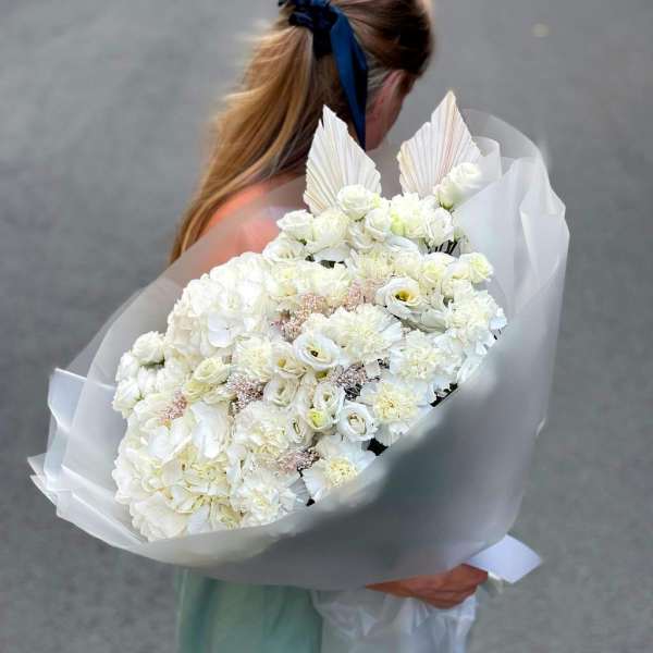 Large white bouquet wrapped in translucent paper