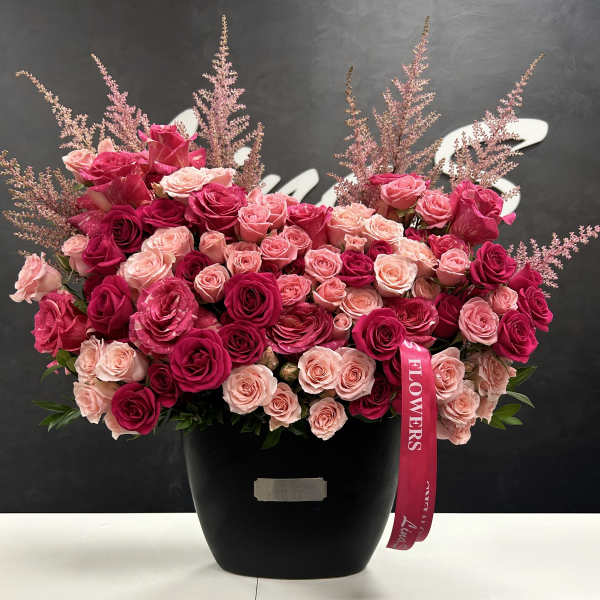 Large bouquet of pink and red roses in a black vase