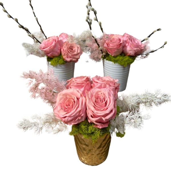 Pink roses arranged in small pots with decorative branches