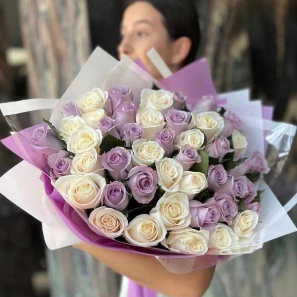 Bouquet of lavender and white roses wrapped in purple paper