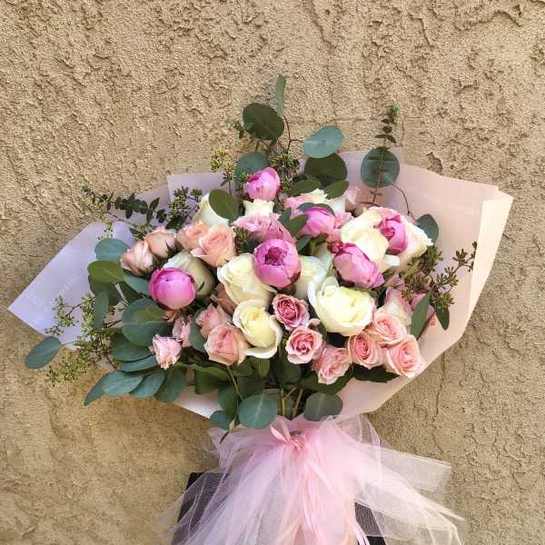Bouquet of pink and white roses with eucalyptus and a pink tulle bow