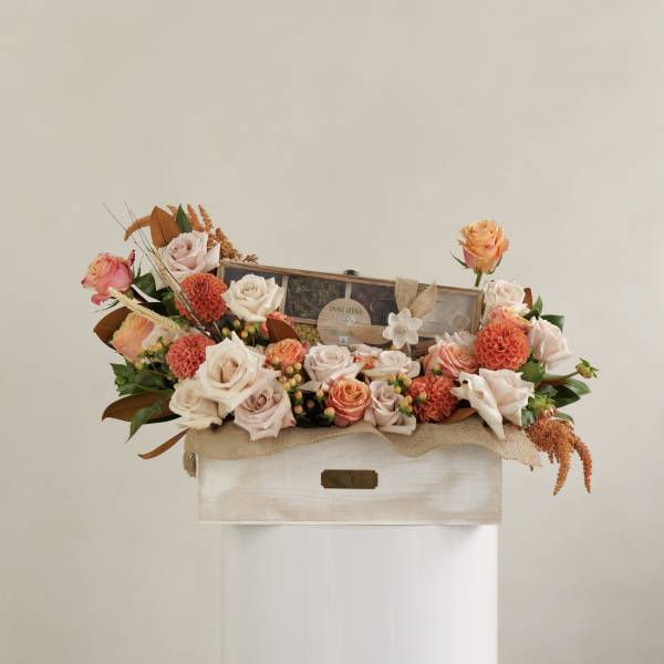 Mixed rose arrangement in a wooden box with a tea gift set