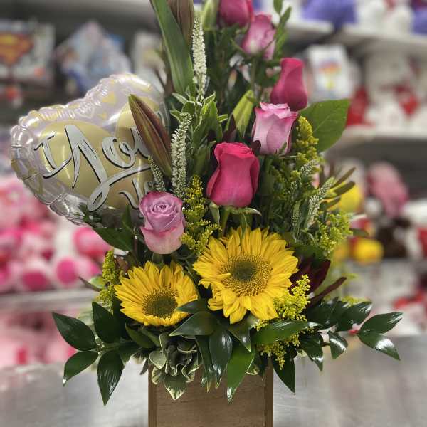 Mixed bouquet with yellow sunflowers, pink roses, and a heart balloon in a wooden box