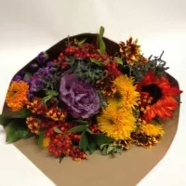 Mixed bouquet with purple, yellow, orange, and red flowers in brown paper
