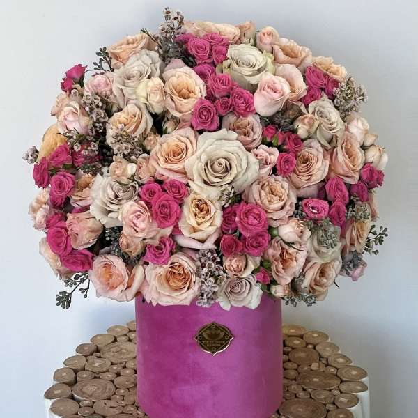 Large bouquet of pink and blush roses in a magenta hatbox