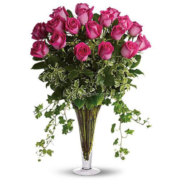 Pink roses in a tall clear vase with trailing ivy