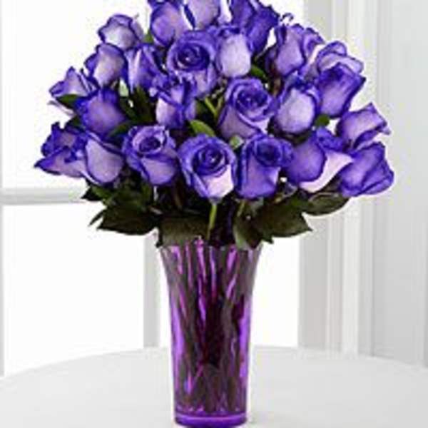 Purple roses arranged in a tall purple vase