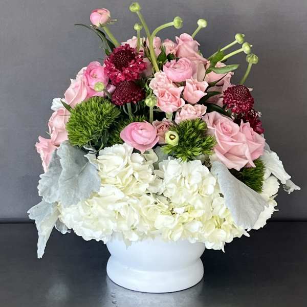 Pink and white floral arrangement in a white vase