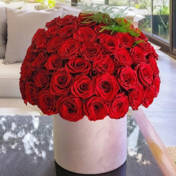 Large bouquet of red roses in a white cylindrical vase