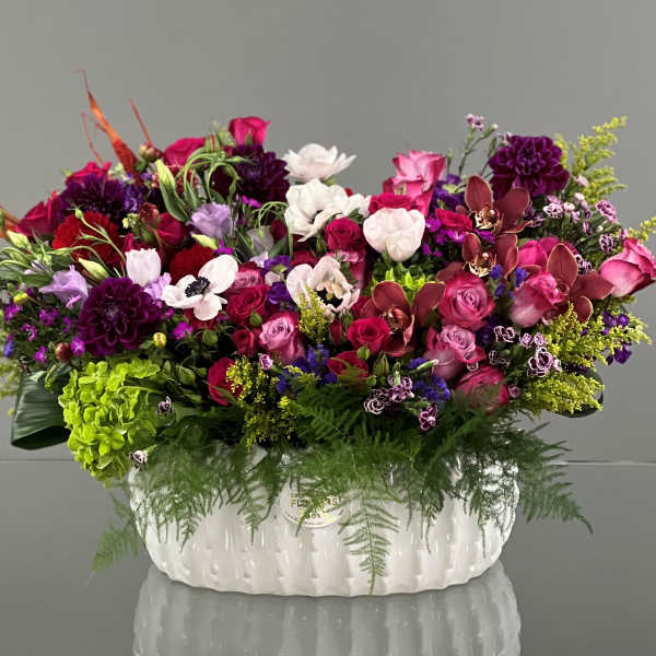 Large mixed floral arrangement in a white ceramic container
