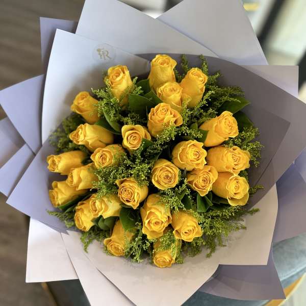 Bouquet of yellow roses wrapped in white paper