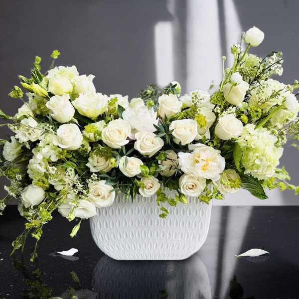 White roses and green-white flowers in a white textured vase