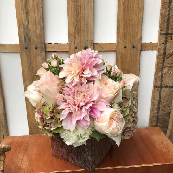 Pink and cream floral arrangement in a textured brown vase