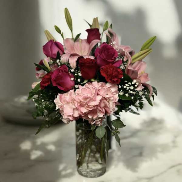Bouquet of pink and red flowers in a clear glass vase