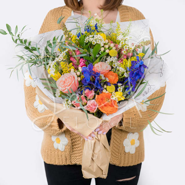 Large mixed bouquet with colorful flowers wrapped in paper