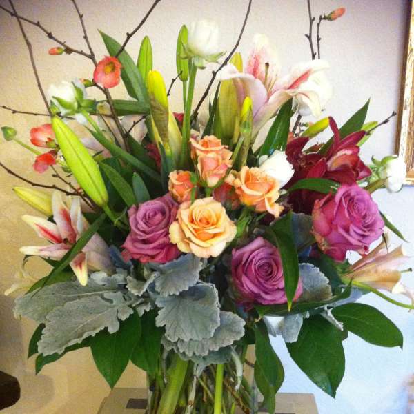 Mixed bouquet of roses and lilies in a clear glass vase