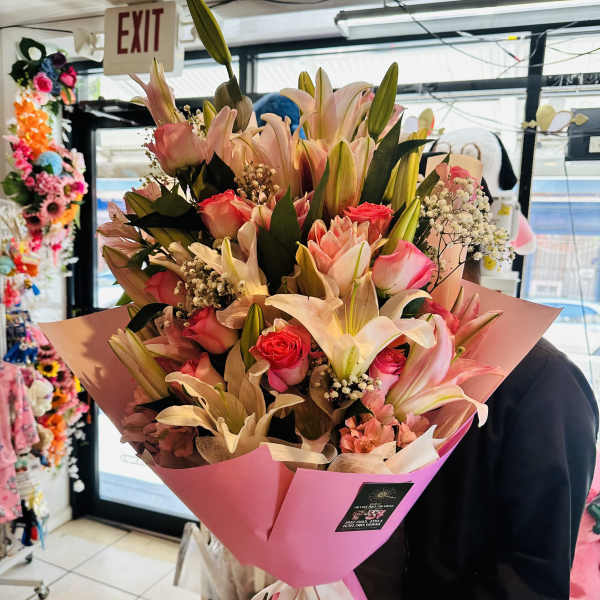 Large pink bouquet of lilies and roses wrapped in pink paper