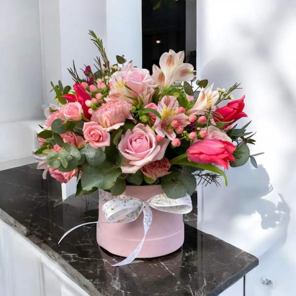 Pink and white mixed flower arrangement in a pink hat box with ribbon